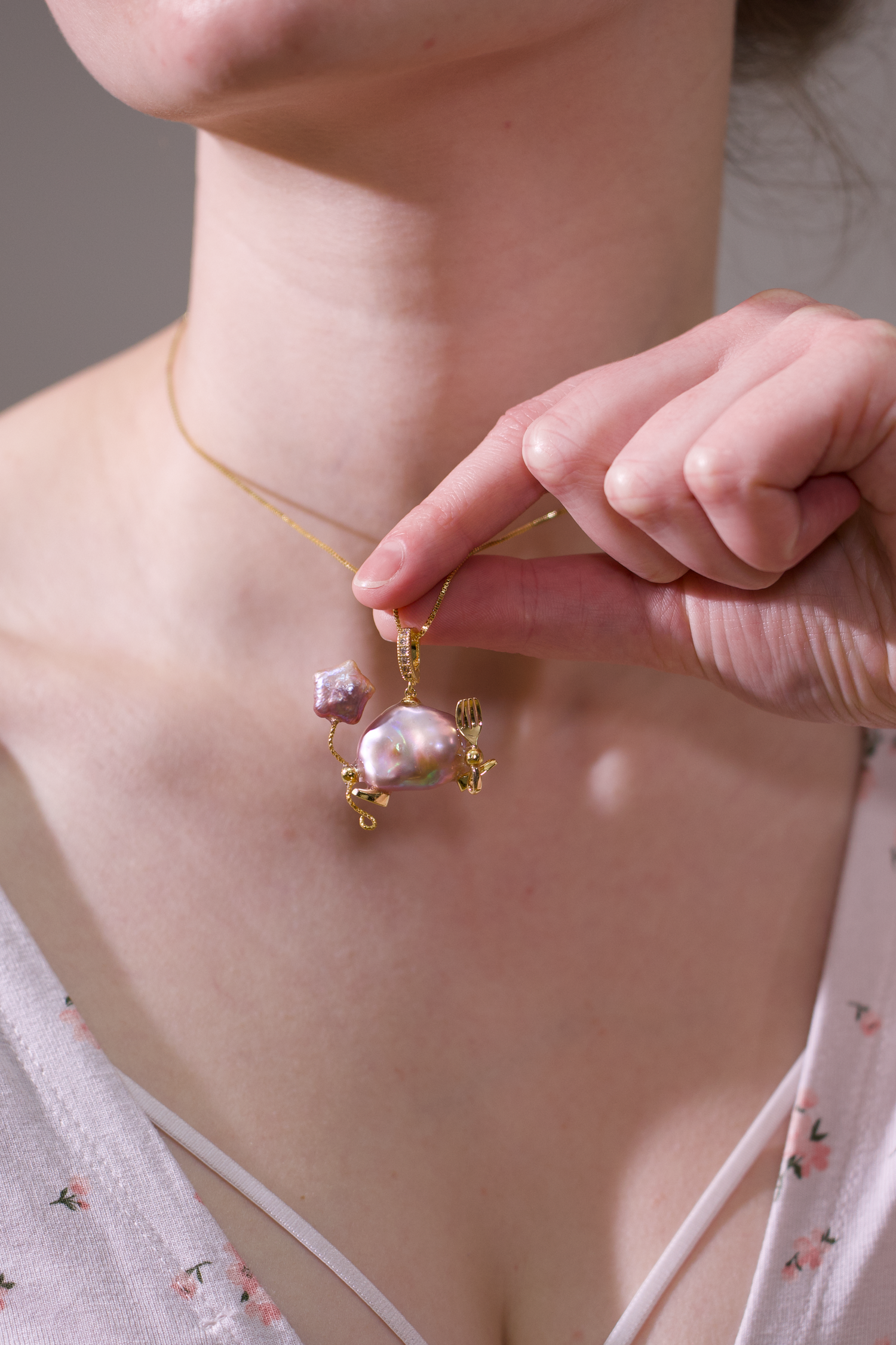 Model wearing a handmade baroque pearl necklace with an inlaid pearl pendant