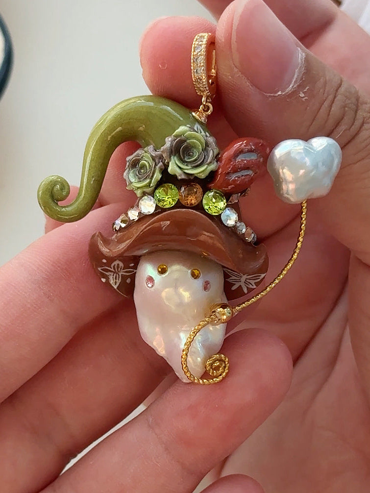 [PIECE10] Bakery Sprite baroque pearl necklace with taupe bagel-inspired hat, sculpted bagel detail, floral accents, gold wand, and natural baroque pearl