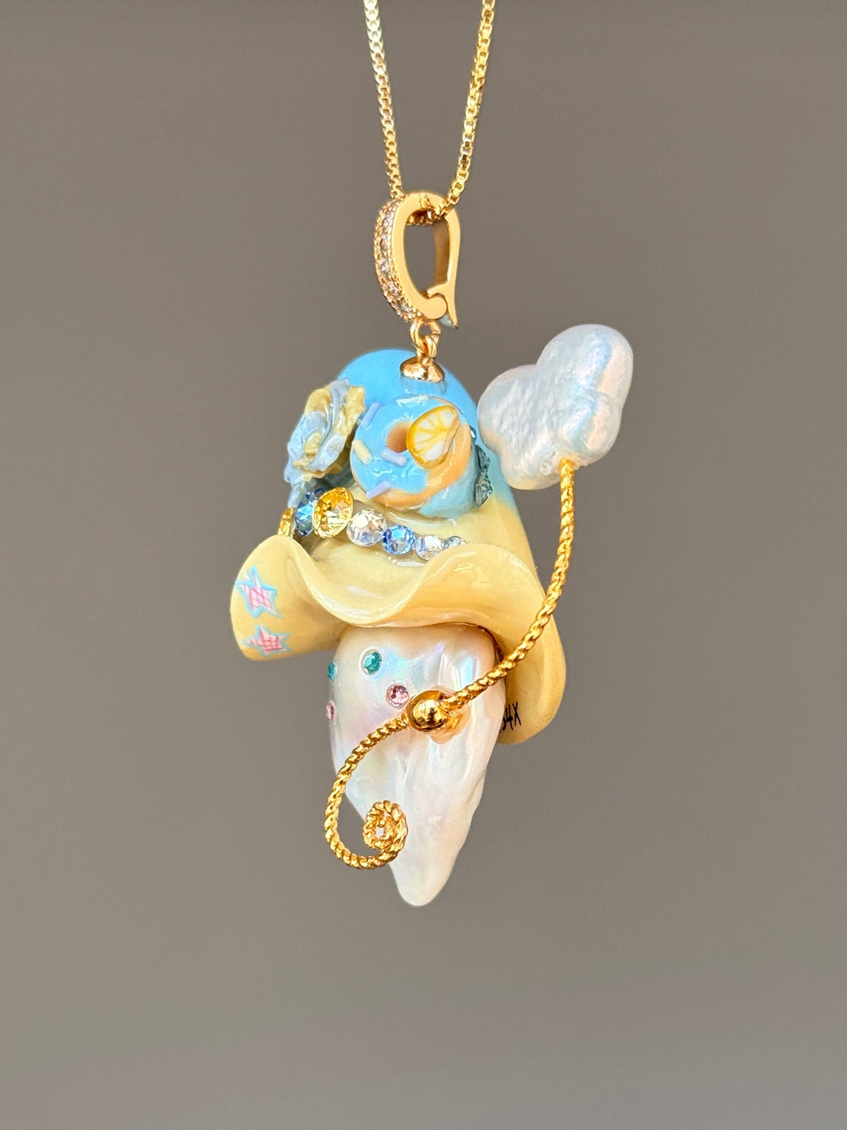 [PIECE02] Donut Dream Sprite baroque pearl necklace with donut-inspired hat, sculpted frosted donut, pastel floral accents, sparkling stones, whimsical candy-colored details, and natural baroque pearl