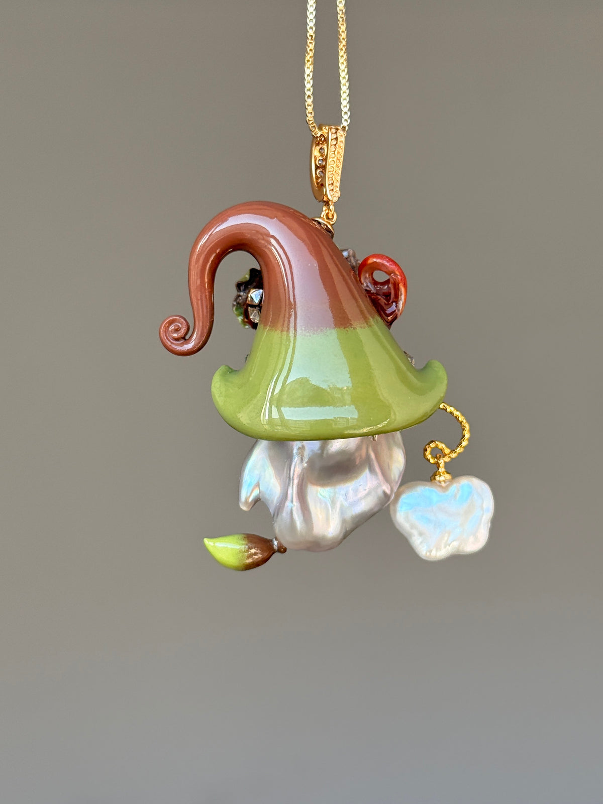 [PIECE07] Bakery Sprite baroque pearl necklace with olive green pretzel-inspired hat, sculpted pretzel detail, floral accents, gold wand, and natural baroque pearl