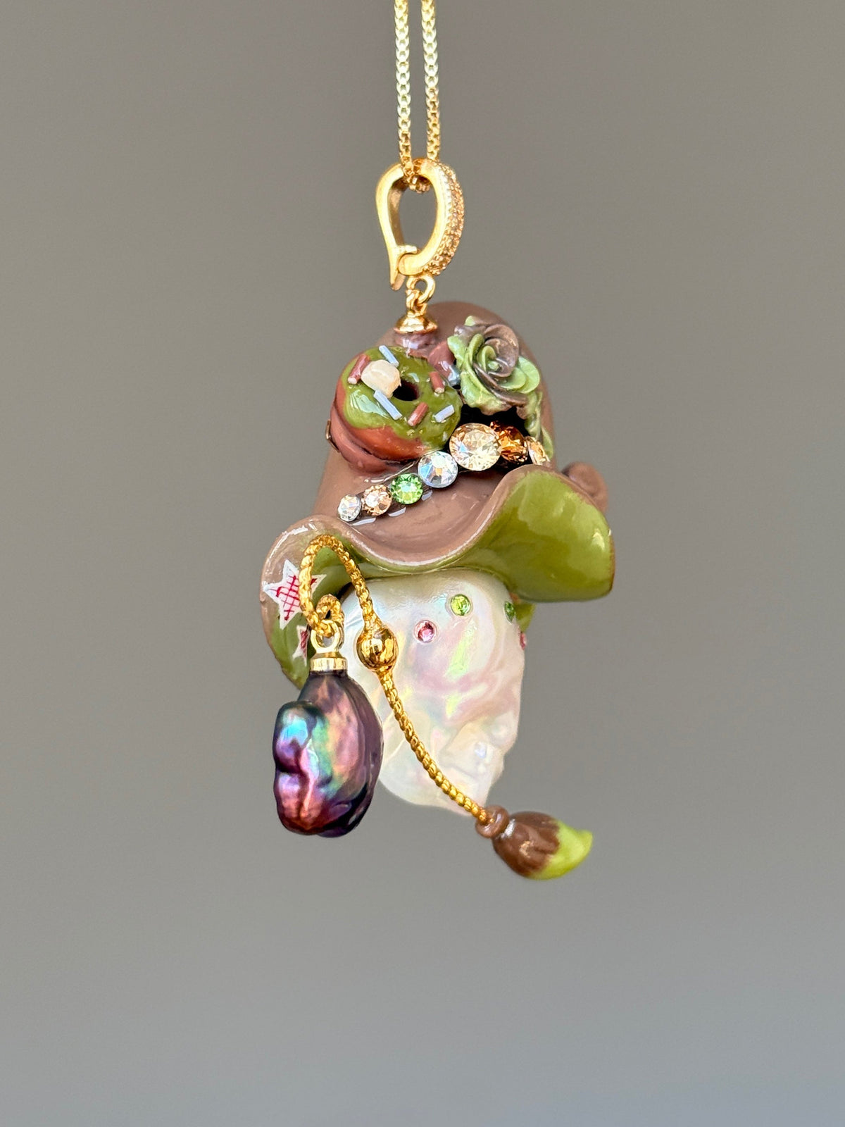 [PIECE01] Donut Dream Sprite baroque pearl necklace with yellow donut-inspired hat, sculpted pink frosted donut, pastel roses, sparkling stones, star details, pink curled accent, pearl charm, paintbrush detail, and natural baroque pearl