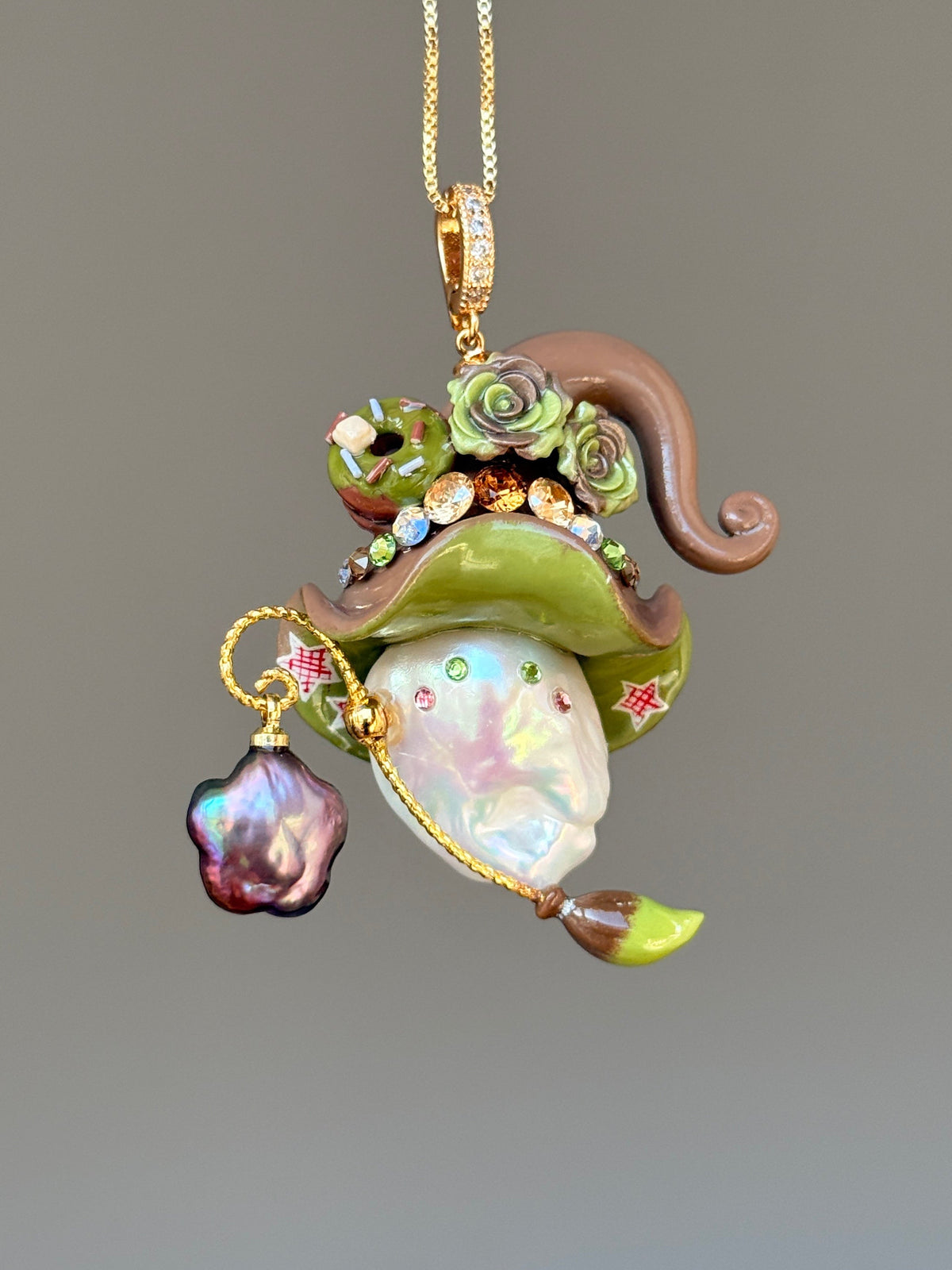 [PIECE01] Donut Dream Sprite baroque pearl necklace with yellow donut-inspired hat, sculpted pink frosted donut, pastel roses, sparkling stones, star details, pink curled accent, pearl charm, paintbrush detail, and natural baroque pearl