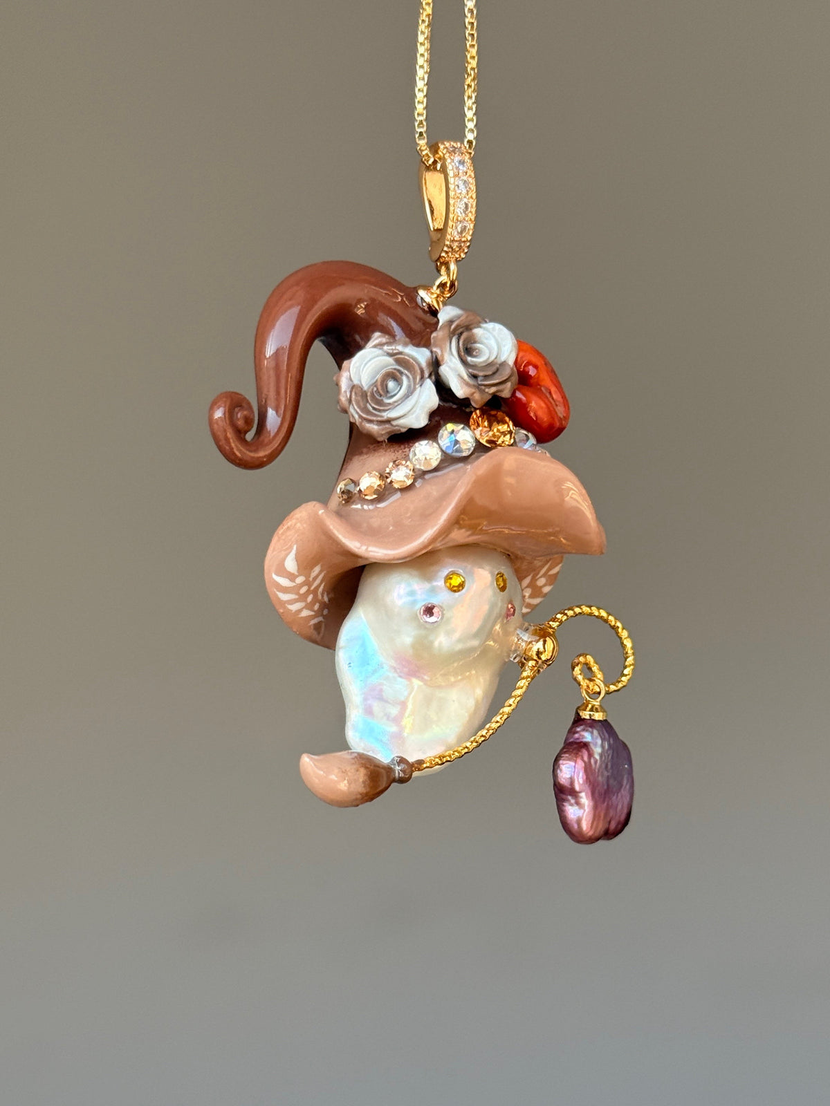 [PIECE09] Bakery Sprite baroque pearl necklace with taupe bagel-inspired hat, sculpted bagel detail, floral accents, gold wand, and natural baroque pearl