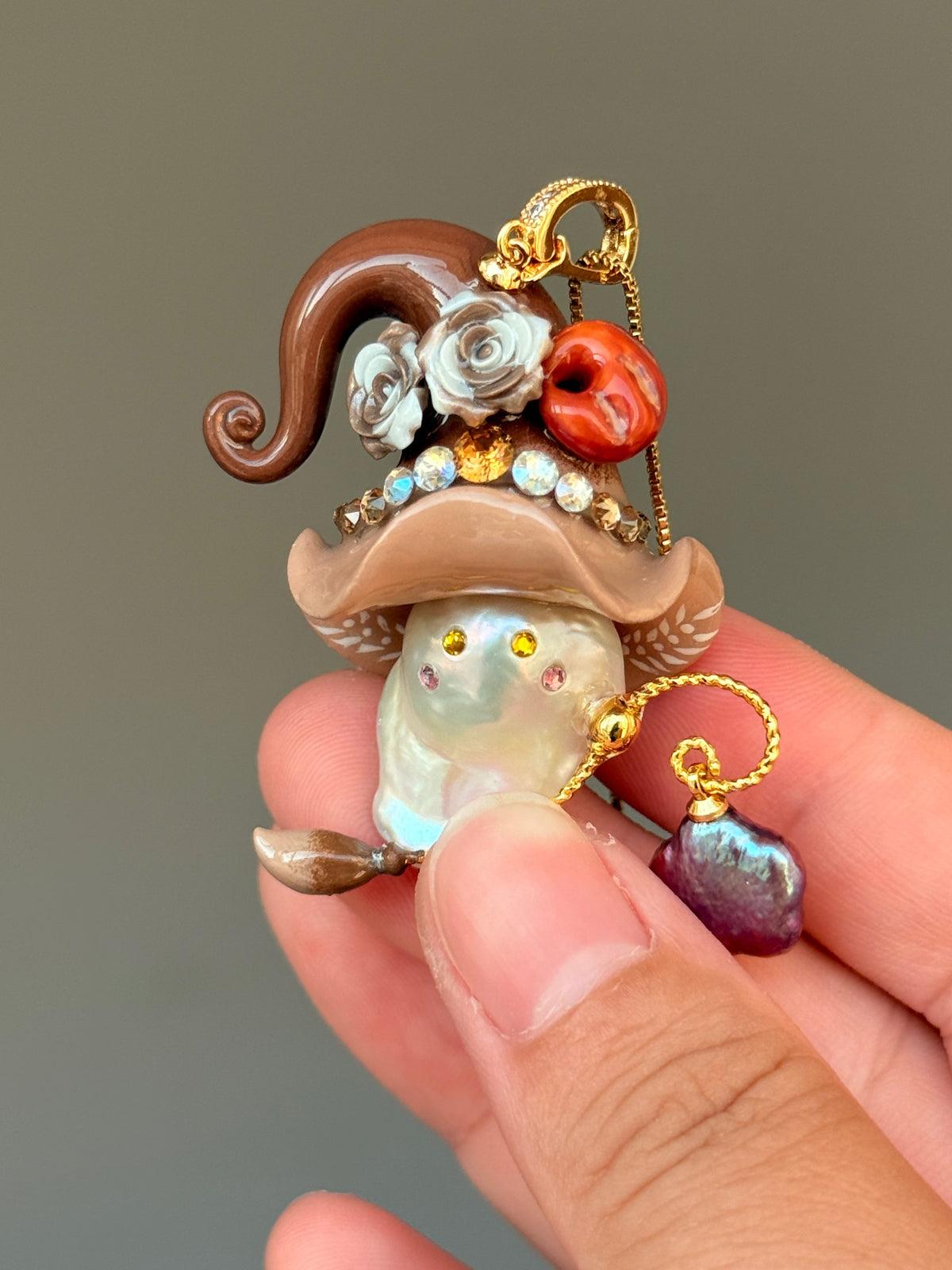 [PIECE09] Bakery Sprite baroque pearl necklace with taupe bagel-inspired hat, sculpted bagel detail, floral accents, gold wand, and natural baroque pearl